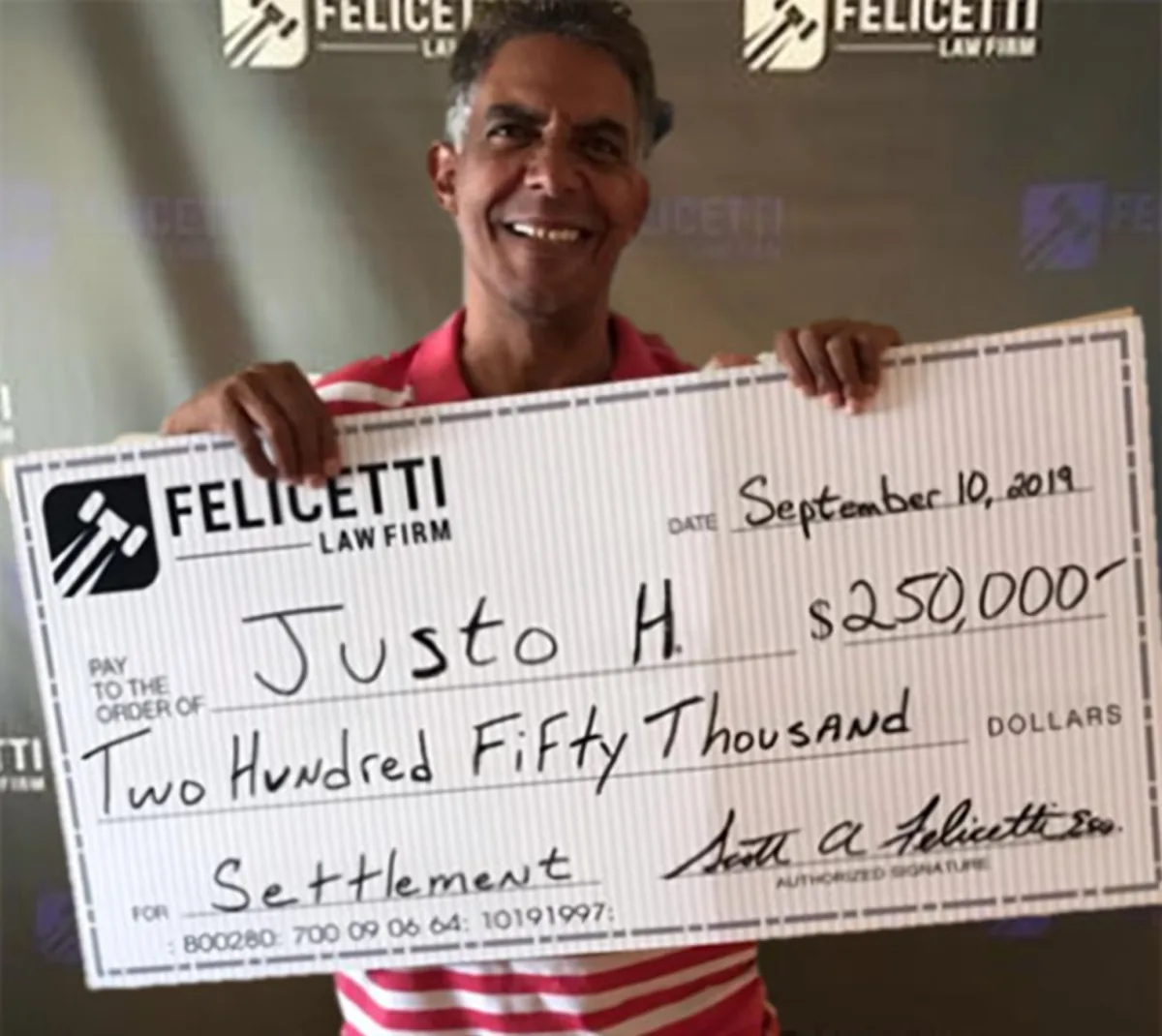 Felicetti Law Firm client holding a $250,000 settlement check